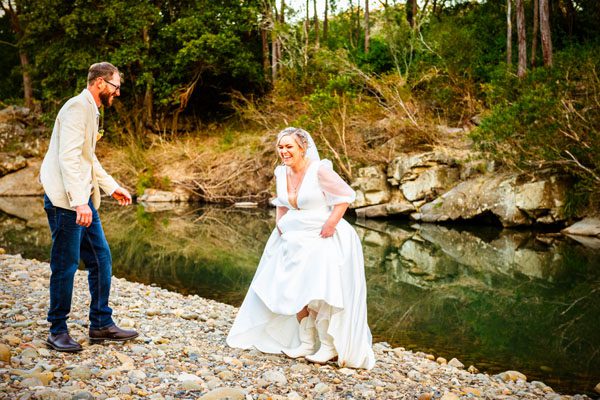 Bride having fun by the river